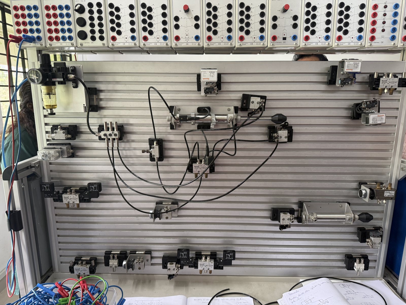 A pneumatics training board with valves, cylinders and tubing