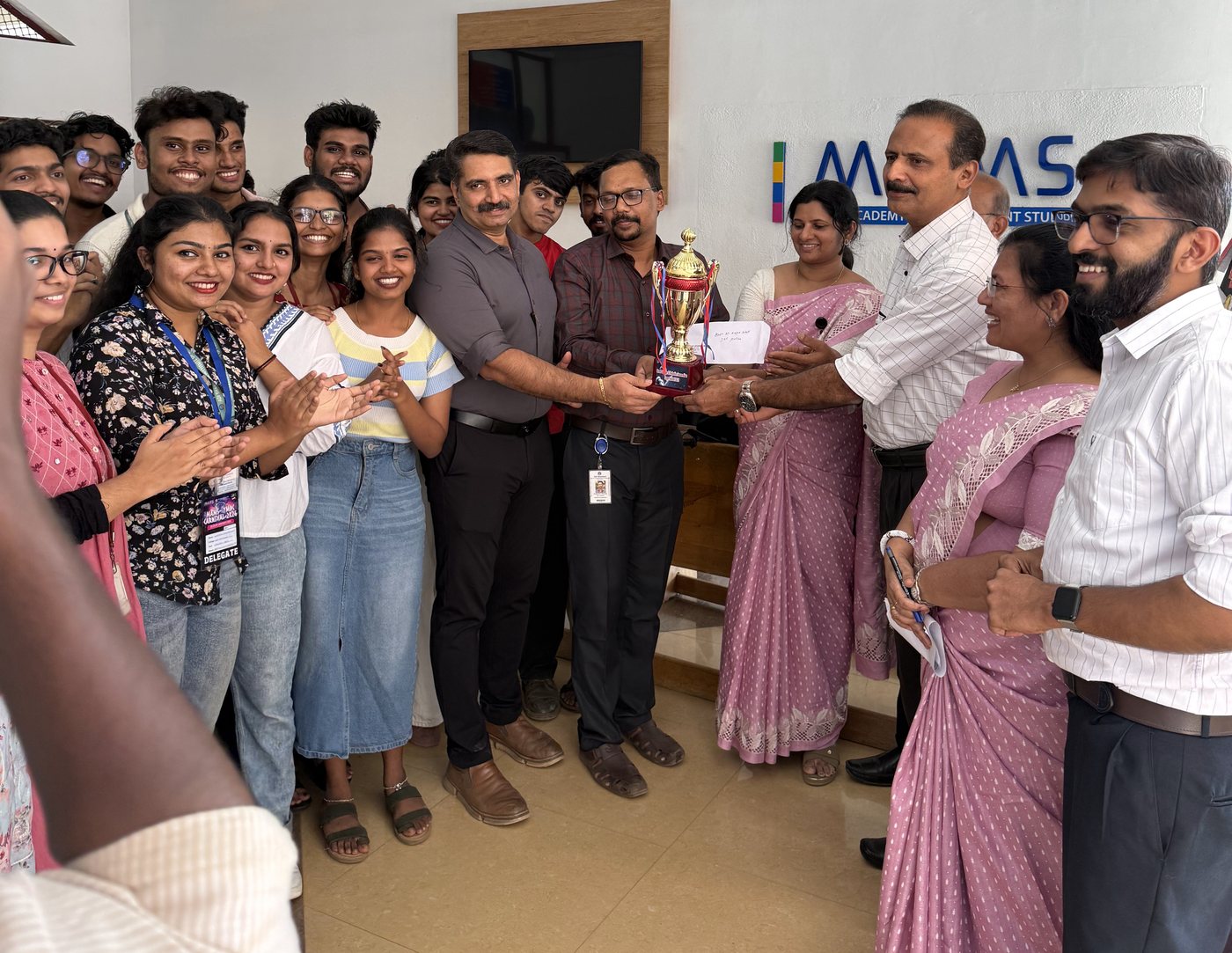 Students and faculty receiving a trophy at an award ceremony