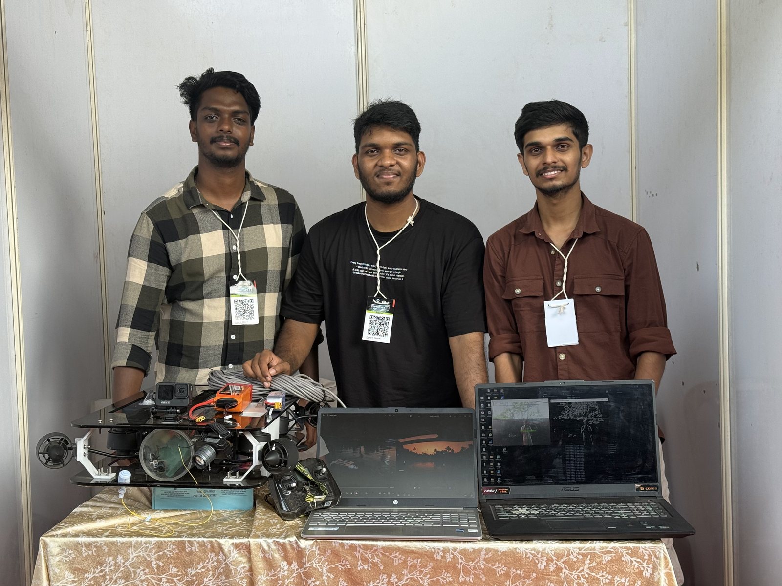 Dino Davis and two teammates behind the rover and two laptops running the control station