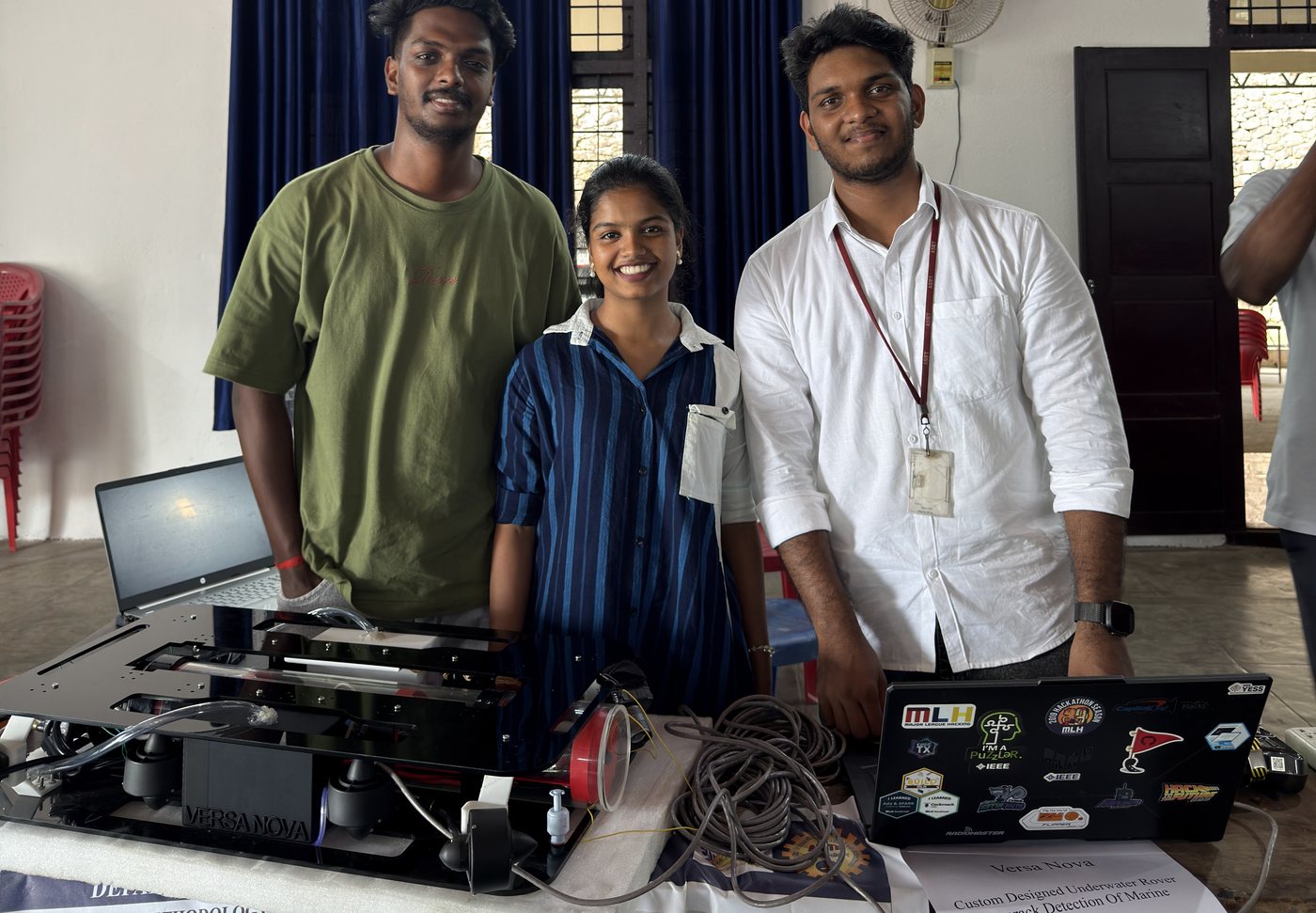 Dino Davis and teammates at an exhibition table with the Versa Nova rover